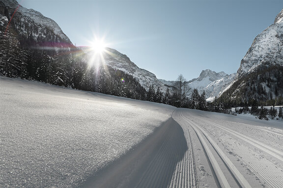 Gespurte Langlaufloipe im Schnee bei Sonnenschein