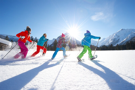 Familie beim Schneeschuhwandern im Schnee