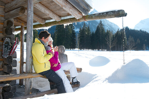 Paar entspannt in einer urigen Winterhütte am Achensee im Schnee
